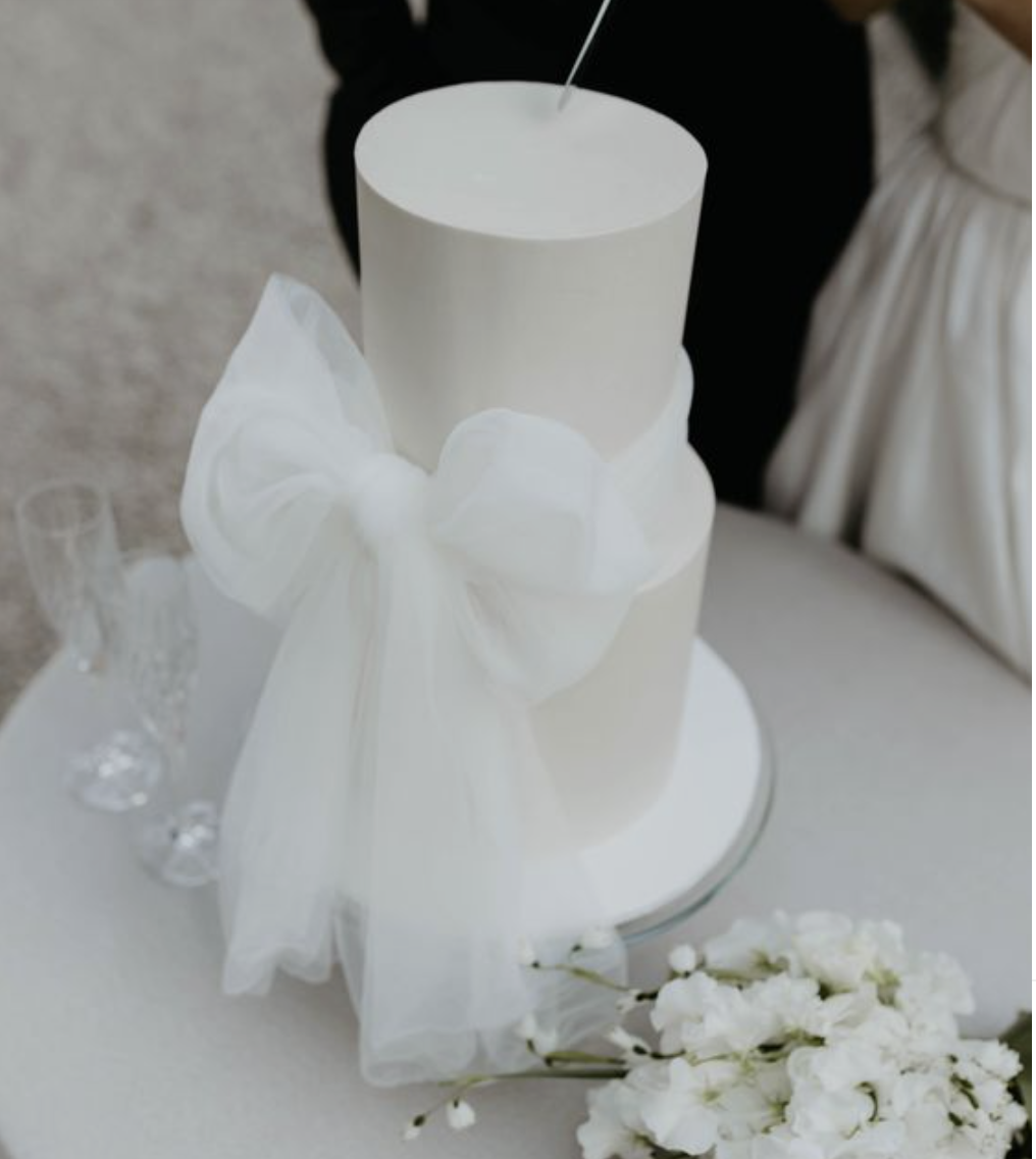 bow on white wedding cake, pretty wedding trends